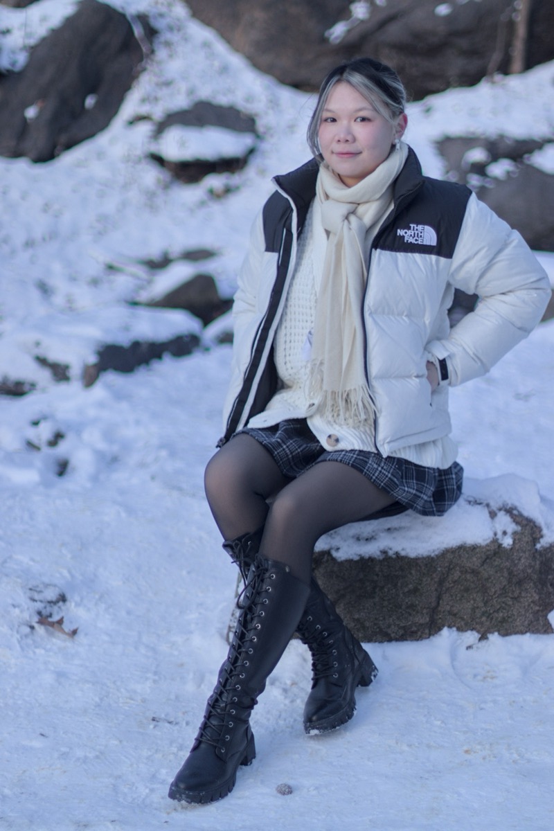 Faye sitting on a log in the snow