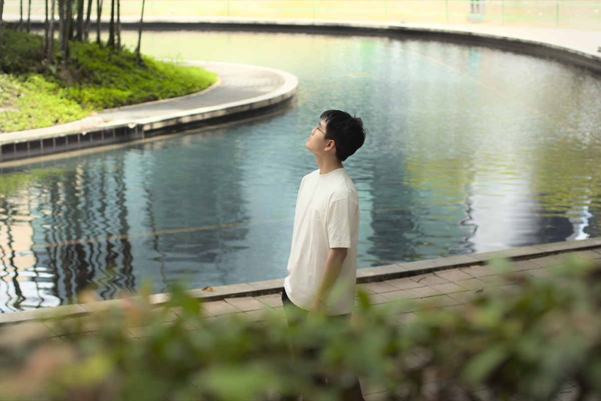 Ryan walking through a park with a lake
